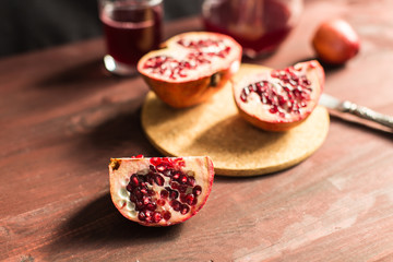 Pomegranate slices and garnet fruit seeds on table