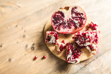 Pomegranate slices and garnet fruit seeds on table