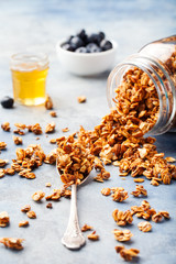 Healthy breakfast Fresh granola, muesli with berries in a glass jar on a stone background
