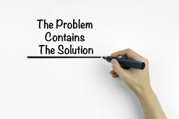 Hand with marker writing: The Problem Contains The Solution