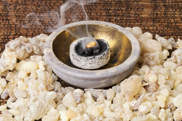 Frankincense burning on a hot coal. Frankincense is an aromatic resin, used for religious rites,...