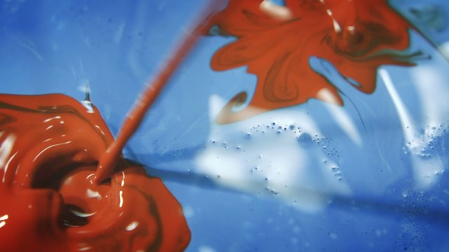 Blue and Red Paint - A high speed macro shot of red streams of paint landing in blue paint.