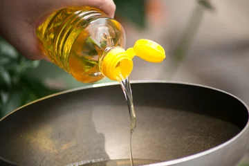 Foto op Plexiglas Gieten van voedselolie in hete pan voor frituren. © Quality Stock Arts