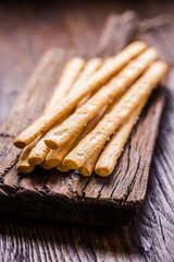 Bread sticks with salt on wooden board