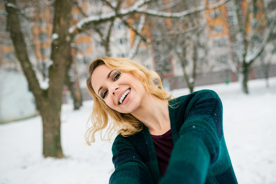 Blond woman taking selfie outside in winter nature