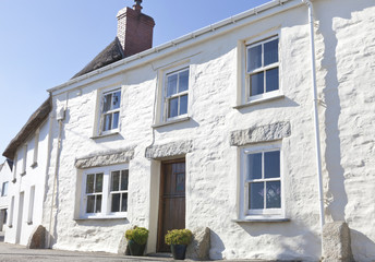 Old Cornish fishing street with traditional white cottages in costal Cornwall village in south west England