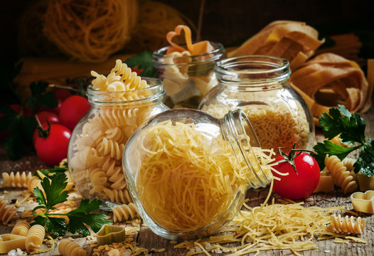 Dry Italian pasta fedelini in a glass jar, assorted mix of diffe
