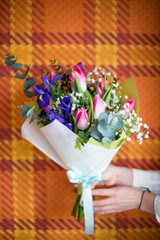 Florist hands showing bouquet of spring flowers. Selective focus.