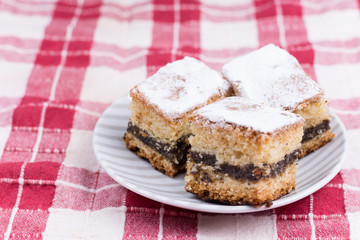 Cakes with poppy seed on the red and white tablecloth