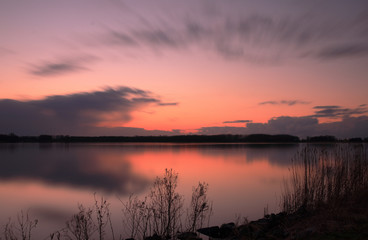 Fototapeta na wymiar Zonsondergang in het Twiske reacreatiegebied met spiegelend meer