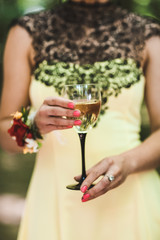 A woman with a glass of champagne wearing a cream-colored dress