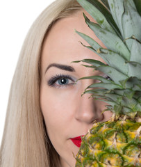 beautiful girl with bright makeup hiding behind the pineapple