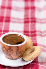 Black coffee with round tea cookies on the plate