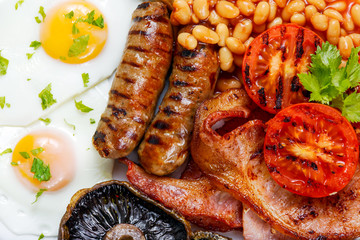 Full English breakfast with bacon, sausage, egg, beans and mushrooms