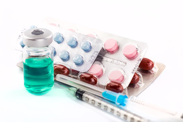Various cold prescription bottles and a syringe isolated on a wh