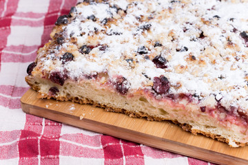 Grandmothers cake with cherries on the wooden board