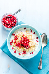 Homemade porridge with pomegranate seeds, overhead.