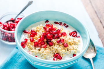 Homemade porridge with pomegranate seeds, overhead.