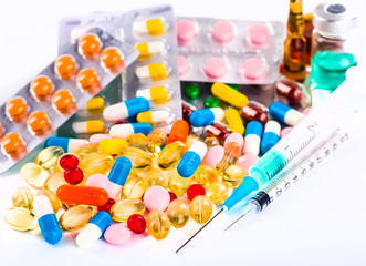 Various cold prescription bottles and a syringe isolated on a wh