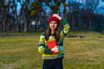 Holding book and hat.