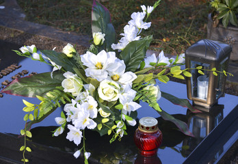 Blumengesteck mit Kerze und Grablampe