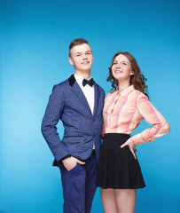 Smiling hipster couple in the jacket and dress in the studio