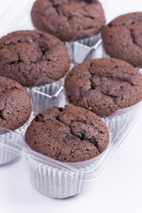 Bunch of brown chocolate muffins over white background