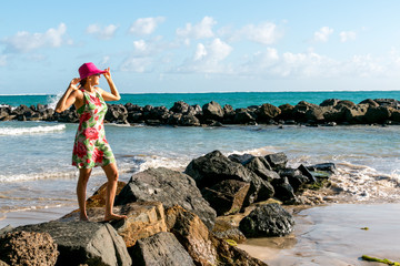Woman at beach standing on rocks 