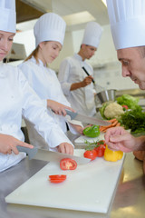 Chef watching students chop vegetables