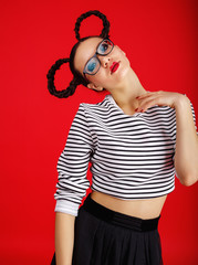 High fashion girl in the glasses with unusual hairstyle like Minnie Mouse in the studio