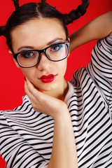 High fashion girl in the glasses with unusual hairstyle like Minnie Mouse in the studio