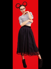 High fashion girl in the glasses with unusual hairstyle like Minnie Mouse in the studio