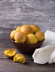 Vegetarian orange buns in ceramic bowl on wooden table