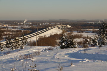 Снежное поле, ели в снегу и дорога, уходящая вдаль
