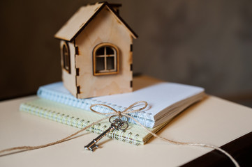 Conceptual image with small wooden house and keys