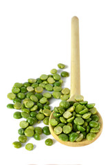 Dried split peas in wooden spoon isolated on white background