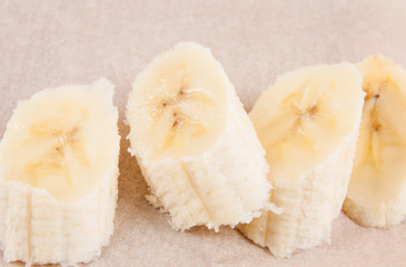 Sliced banana in glass on white wooden background. Selective focus.