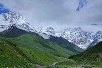 Fototapeta premium Beautiful view of rural alpine landscape. Sunny hills under cloudy sky. Upper Svaneti, Georgia, Europe. Caucasus mountains. Beauty world.