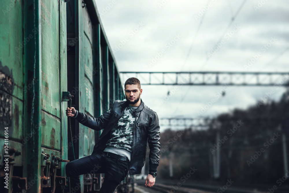 Wall mural Man with beard walking on the railway