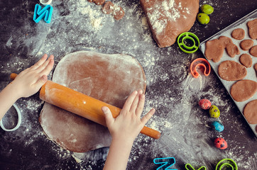 Young girl's hands sheeting dough with rolling pin