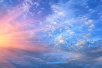 powerful rays of the sun on a background of white clouds .