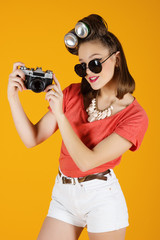 Young attractive fashionable woman with old-school camera wearing glasses
