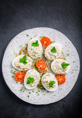 Deviled eggs with mushrooms, mayonnaise and cherry tomatoes on cress sprouts