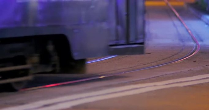 Tram on street of Hong Kong at night close up view. City details scene