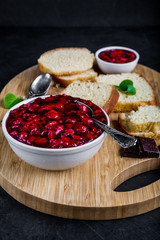 Cherry jam in white bowl and on yeast cake