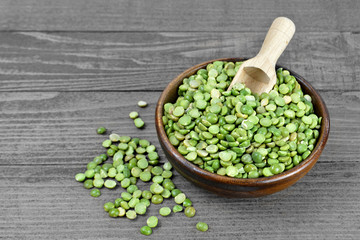 Green lentil beans in bowl on old wooden background
