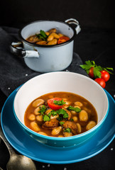 Hot baked beans with tomato and parsley in bowl