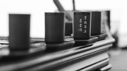 Fototapeta premium Several authentic cups for tea ceremony with hieroglyphs black and white close-up
