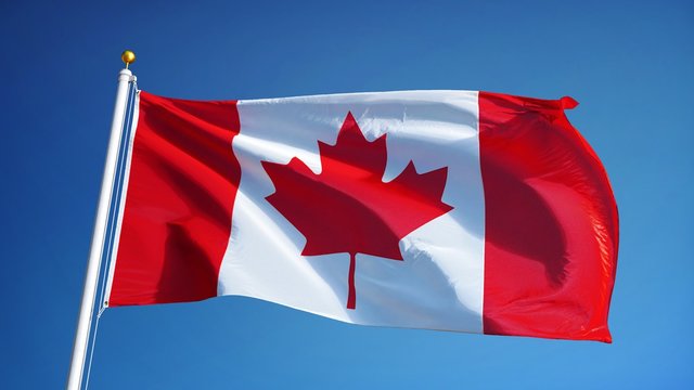 Canada flag waving in slow motion against blue sky, seamlessly looped, close up, isolated on alpha channel with black and white luminance matte, perfect for film, news, digital composition