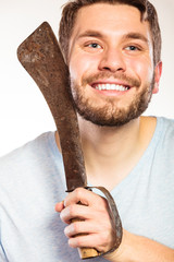 Young man shaving having fun with machete.